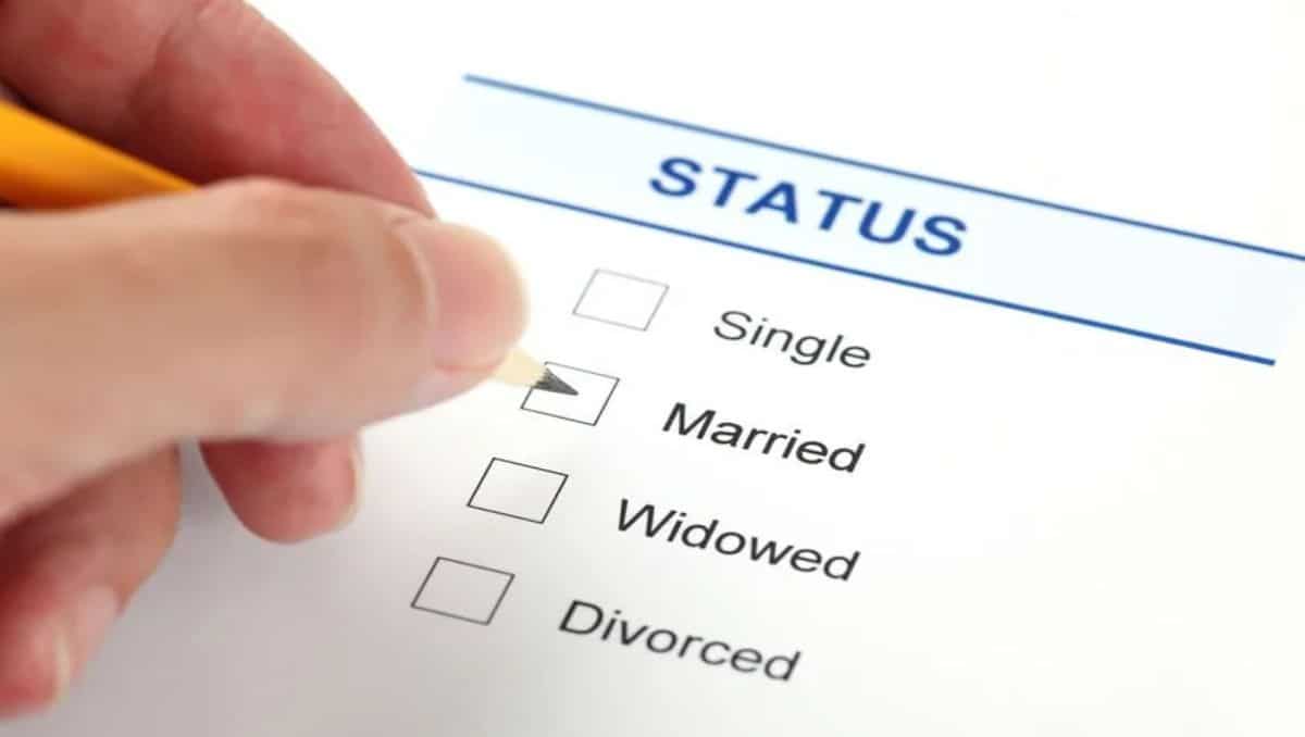 A hand checking a marital status document. 